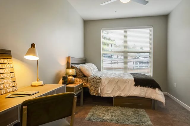 Desk bed nightstand lamp bedding rug bedroom at The Lookout on Cragmor in Colorado Springs Student Accommodation