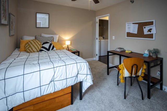 Bed desk chair and laundry visible bedroom at SQ Johnson City in Johnson City Student Accommodation