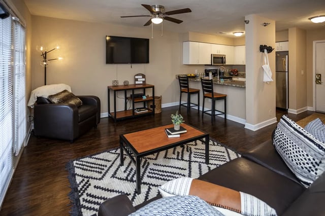Sofa coffee table rug kitchen bar stools living room at SQ Johnson City in Johnson City Student Accommodation