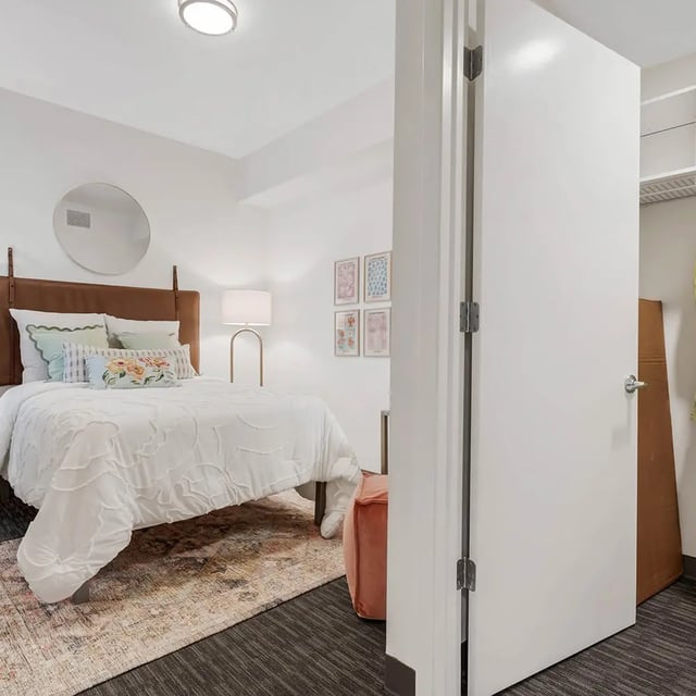 Bed with pillows mirror lamp rug bedroom at Social28 in Gainesville Student Accommodation