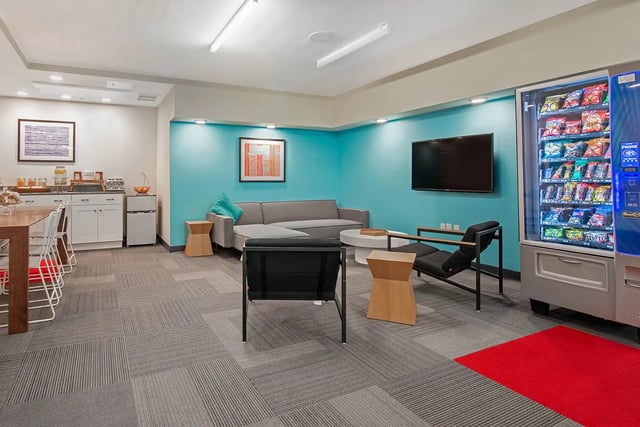 Sofa chairs coffee table TV vending machine lounge at Social28 in Gainesville Student Accommodation