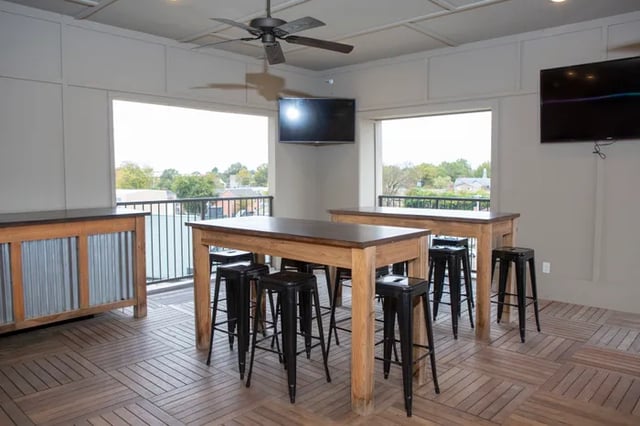 Two high tables with bar stools living room at Balcony Starkville in Starkville Student Accommodation