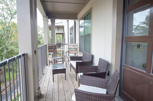 Wicker chairs glass table balcony exterior at Balcony Starkville in Starkville Student Accommodation
