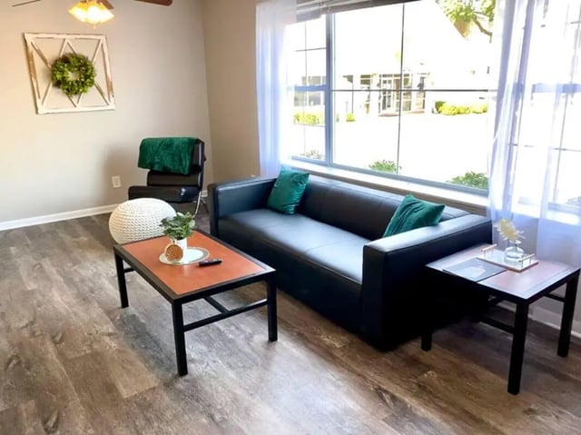 Black sofa green pillows coffee table living room at 1909 Campus Flats in Bowling Green Student Accommodation