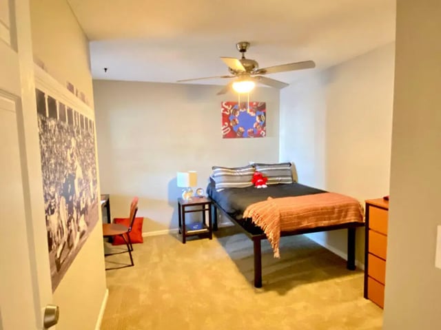 Bed desk chair artwork and ceiling fan bedroom at 1909 Campus Flats in Bowling Green Student Accommodation