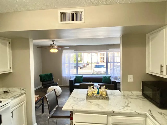 Sofa chairs vent ceiling fan living room kitchen exterior at 1909 Campus Flats in Bowling Green Student Accommodation