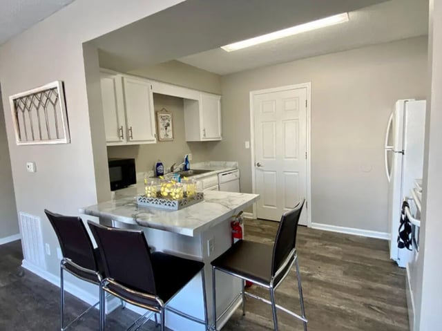 Kitchen island with stools white cabinets appliances kitchen at 1909 Campus Flats in Bowling Green Student Accommodation