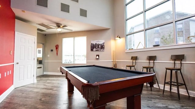 Pool table with chairs and large windows game room at 1909 Campus Flats in Bowling Green Student Accommodation