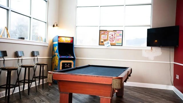 Pool table arcade game and bar stools recreation area at 1909 Campus Flats in Bowling Green Student Accommodation