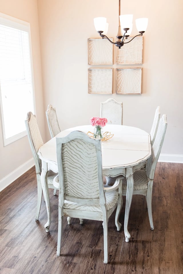 White oval table with pink flowers chandelier and chairs dining room at West 100 Oxford Apartments in Oxford Student Accommodation