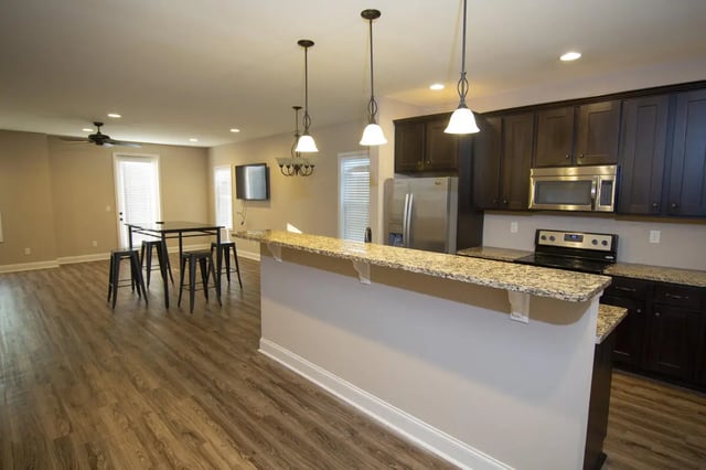 Dining table with stools and kitchen area living room at West 100 Oxford Apartments in Oxford Student Accommodation