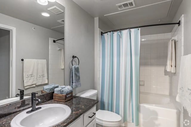 Sink toilet shower with blue striped curtain bathroom at Heron on Hausman in San Antonio Student Accommodation
