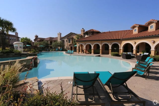 Swimming pool lounge chairs building exterior at Heron on Hausman in San Antonio Student Accommodation
