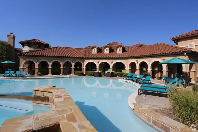 Pool with lounge chairs and building exterior at Heron on Hausman in San Antonio Student Accommodation