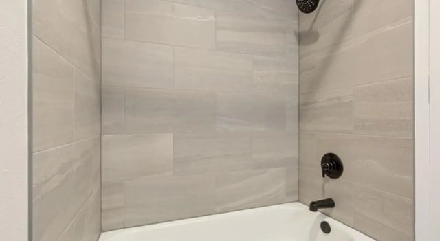 Tiled shower and bathtub with dark fixtures bathroom at Mint Urban Infinity in Denver Student Accommodation