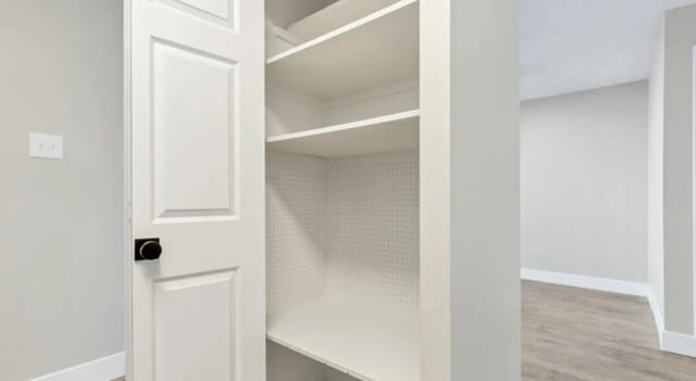 Empty white shelves inside a closet with door at Mint Urban Infinity in Denver Student Accommodation