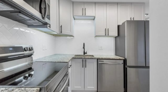 Modern kitchen with stainless steel appliances and white cabinets kitchen at Mint Urban Infinity in Denver Student Accommodation