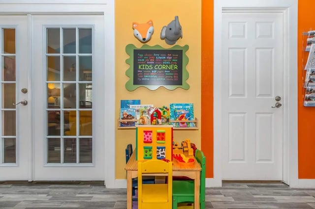 Kids corner with toys books and chalkboard area at Villas De La Plaza in Austin Student Accommodation