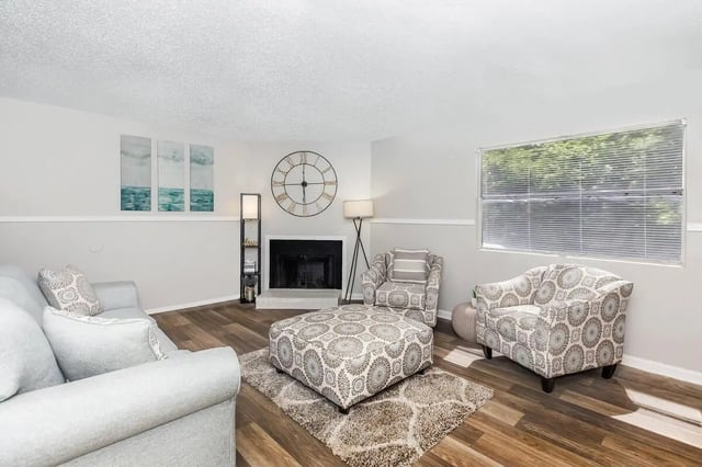 Sofa chairs ottoman fireplace clock artwork living room at Villas De La Plaza in Austin Student Accommodation