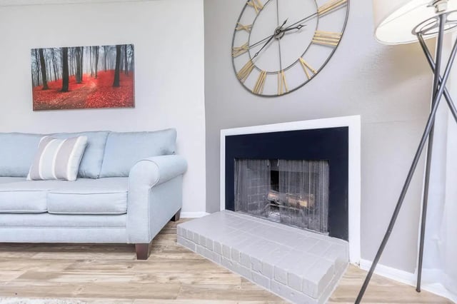 Light blue sofa fireplace artwork clock living room at Villas De La Plaza in Austin Student Accommodation