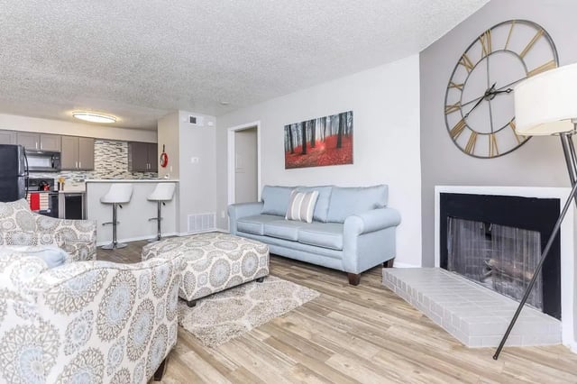 Light blue sofa ottoman fireplace living room at Villas De La Plaza in Austin Student Accommodation