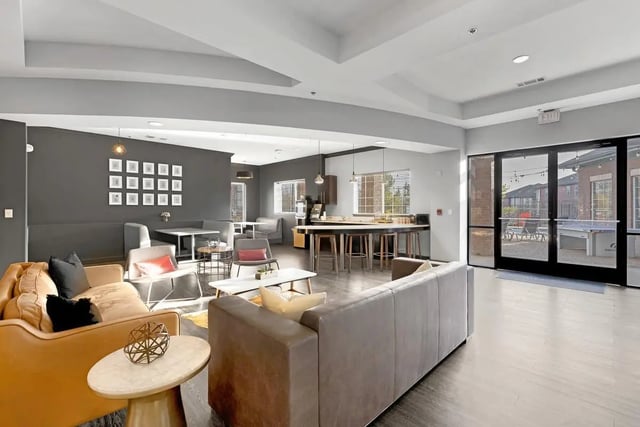 Sofas table kitchen island and ping pong table living area at Hill Place in Fayetteville Student Accommodation