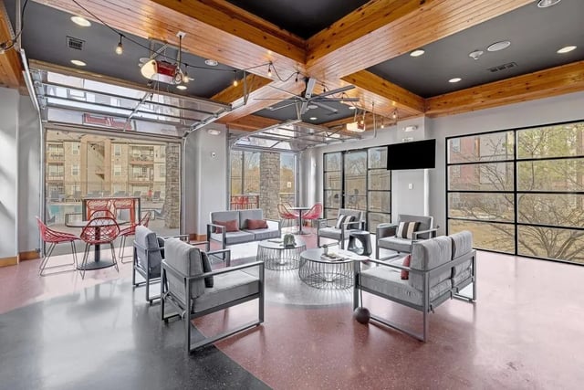 Modern lounge area with gray seating and tables at Hill Place in Fayetteville Student Accommodation