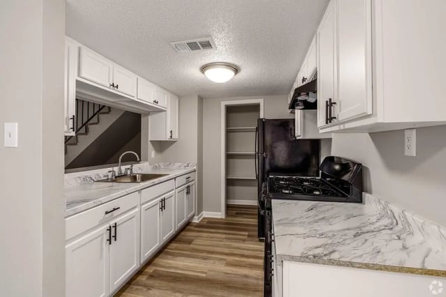 White cabinets sink stove and refrigerator kitchen at Villas De Sendero in San Antonio Student Accommodation