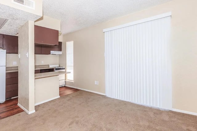 Kitchen counter refrigerator stove and blinds living room at Villas Del Solamar in Dallas Student Accommodation
