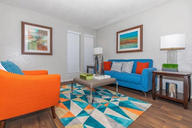 Blue sofa orange chair modern rug living room at Villas Del Solamar in Dallas Student Accommodation
