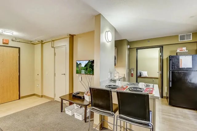 Living room with TV kitchen and refrigerator Living room at Dwell The Towers on State in Madison Student Accommodation