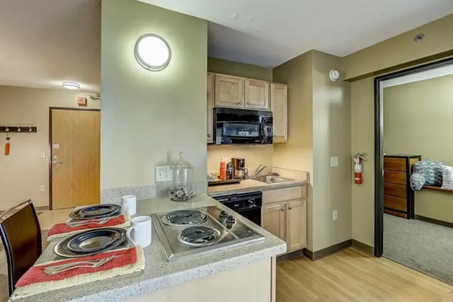 Plates mugs stove and microwave kitchen at Dwell The Towers on State in Madison Student Accommodation