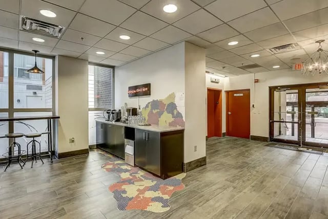 Coffee counter with stools and entry doors communal area at Dwell The Towers on State in Madison Student Accommodation