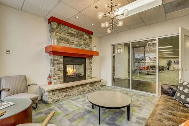 Fireplace chairs couch coffee table living room at Dwell The Towers on State in Madison Student Accommodation