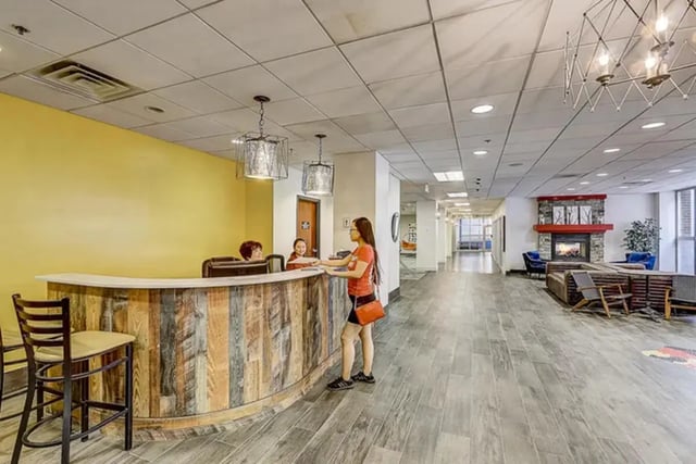 Reception desk with bar stools and fireplace lobby at Dwell The Towers on State in Madison Student Accommodation