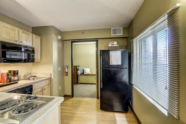 Microwave refrigerator stove sink with cabinets kitchen at Dwell The Towers on State in Madison Student Accommodation