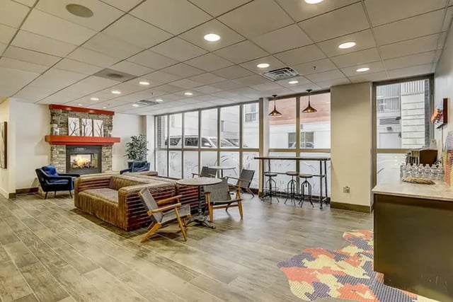 Sofa fireplace seating bar stools living room at Dwell The Towers on State in Madison Student Accommodation