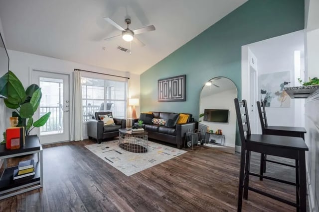 Sofa armchair coffee table rug accent wall living room at Cabana Beach San Marcos in San Marcos Student Accommodation