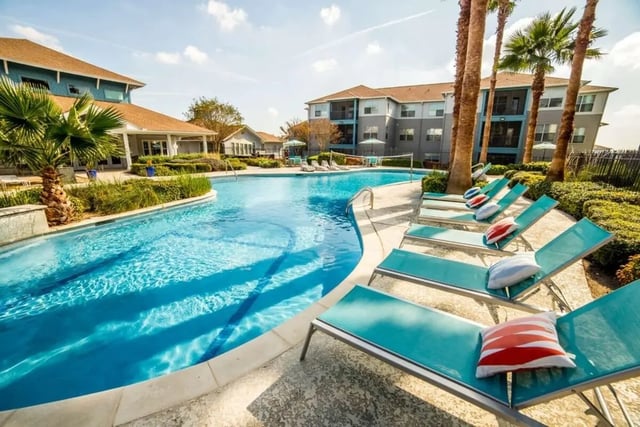 Pool lounge chairs with pillows exterior at Cabana Beach San Marcos in San Marcos Student Accommodation