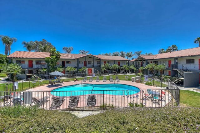 Apartment complex pool with lounge chairs exterior at University Village Fullerton in Fullerton Student Accommodation