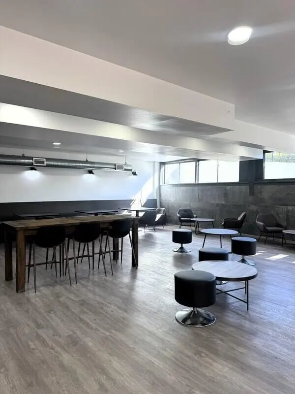 Communal table with bar stools lounge seating living area at University Village Fullerton in Fullerton Student Accommodation