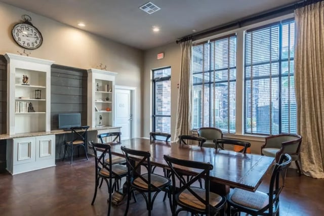 Large dining table with chairs and built-in shelving study area at Varsity House Gainesville in Gainesville Student Accommodation