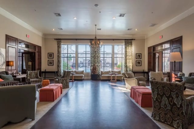 Lounge seating with large windows and chandelier living room at Varsity House Gainesville in Gainesville Student Accommodation