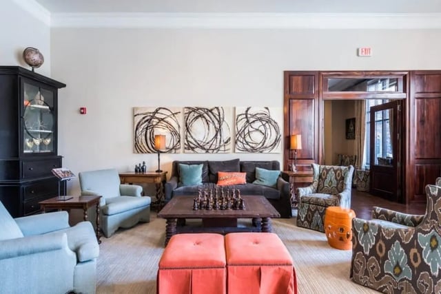 Sofa chairs ottoman artwork and a globe living room at Varsity House Gainesville in Gainesville Student Accommodation