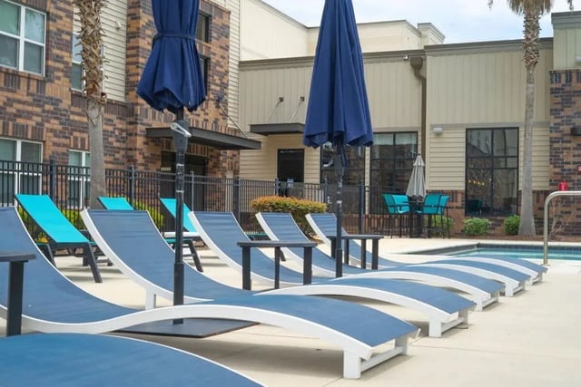 Poolside lounge chairs with umbrellas exterior at Varsity House Gainesville in Gainesville Student Accommodation