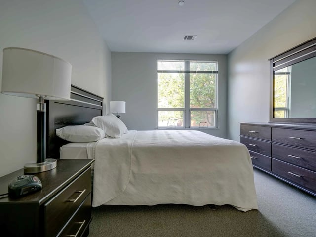 Bed with dresser and lamp Bedroom at College and Crown in New Haven Student Accommodation
