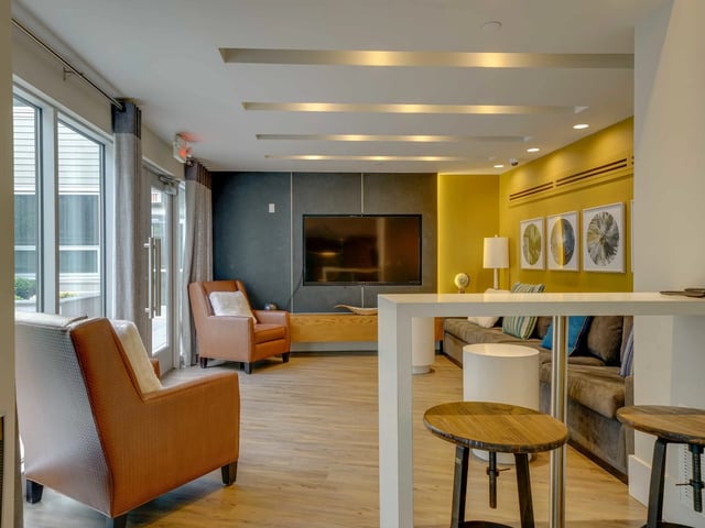 Living room with chairs sofa television and bar at College and Crown in New Haven Student Accommodation