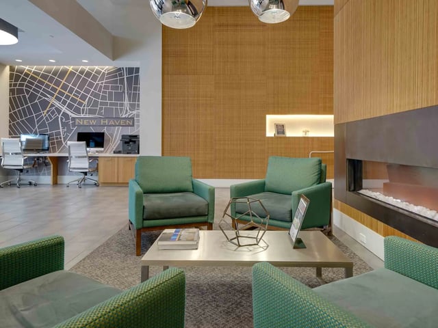 Green armchairs modern fireplace new haven map living room at College and Crown in New Haven Student Accommodation