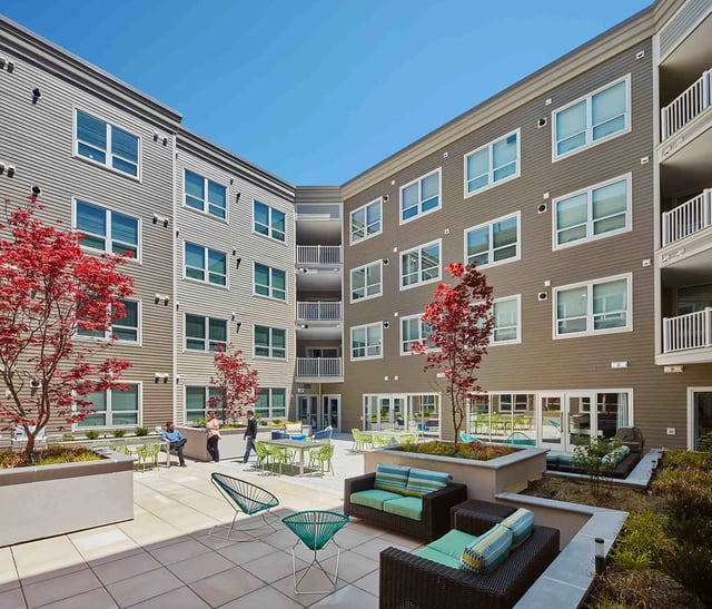 Courtyard with lounge furniture and trees exterior at College and Crown in New Haven Student Accommodation