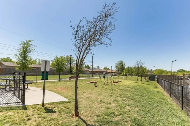 Dog park with agility equipment and picnic table exterior at Millennium in Norman Student Accommodation